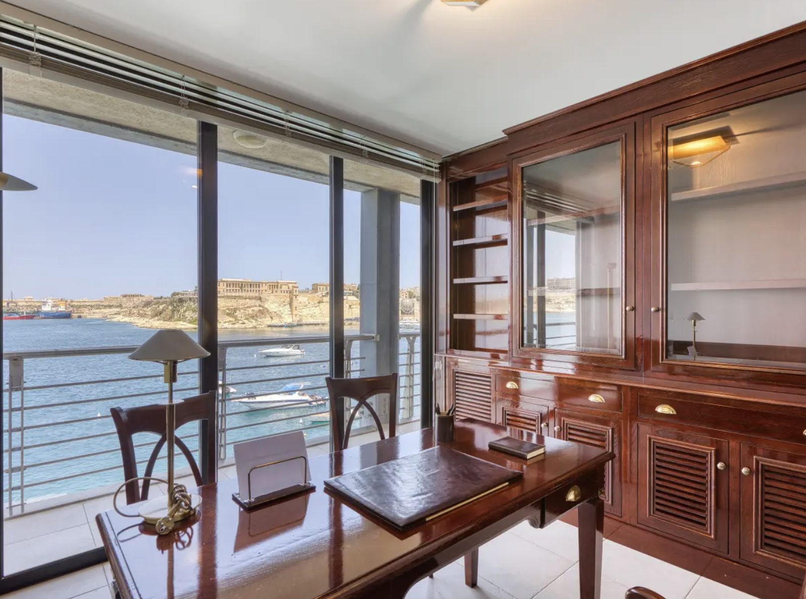 Home office with floor-to-ceiling windows overlooking Grand Harbour and moored yachts, Malta